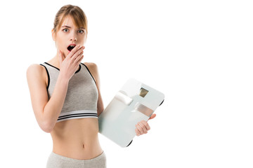 shocked slim woman holding scales isolated on white