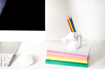 workspace front view computer keyboard mouse and unicorn pencil holder and note books, rainbow...