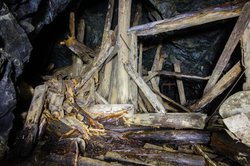 Underground abandoned gold ore mine shaft tunnel gallery with wooden timbering