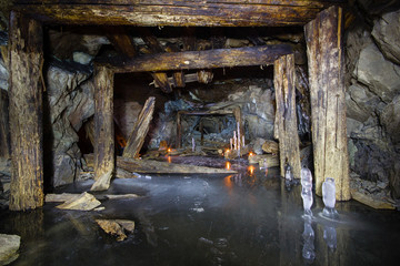 Fototapeta na wymiar Underground abandoned ore mine shaft tunnel gallery with ice stalactites and stalagmites