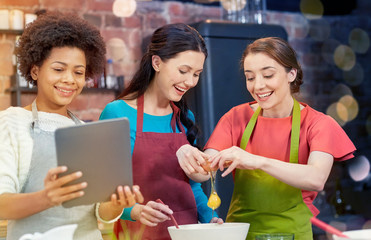 happy women with tablet pc in kitchen