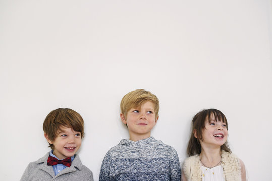 Portrait of three smiling children dressed in smart clothing