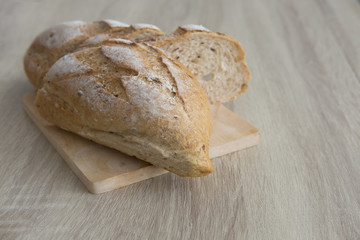 CRUSTY FRENCH BREAD
Two brown crusty sliced french bread on a wood table.
