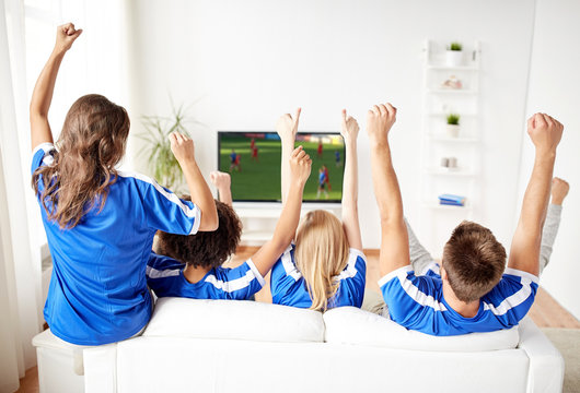 football fans watching soccer game on tv at home