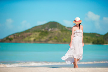 Fototapeta na wymiar Young beautiful woman on tropical seashore. Happy girl relaxing at white sand tropical beach