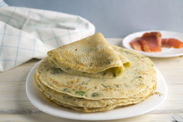 Pancakes with fish, greens and sour cream