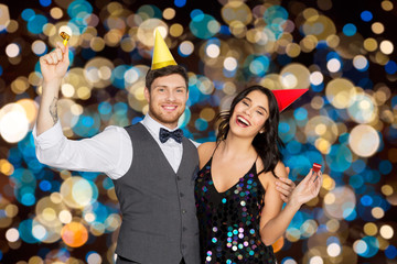 happy couple with party blowers having fun