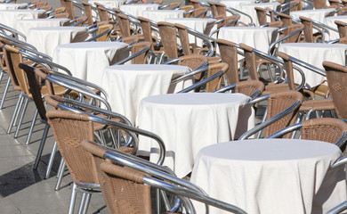 tables of an outdoor bar with white tablecloths