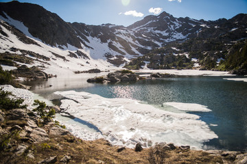 A partially frozen lake in the mountains of Colorado during summer. 