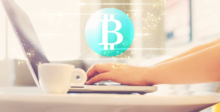 Bitcoin with woman using a laptop in brightly lit room