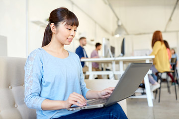 happy asian woman with laptop working at office