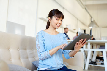 happy asian woman with tablet pc working at office