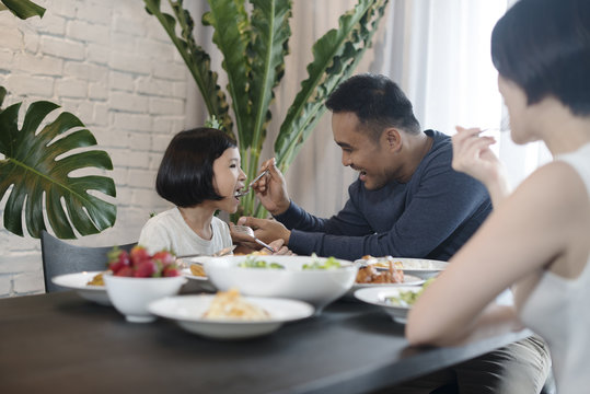 Happy Asian family eating together at home.