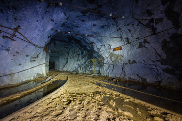 Underground abandoned ore mine shaft tunnel gallery with tails