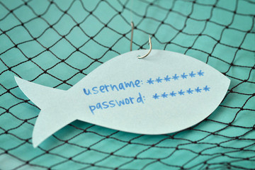 Username and password written on a paper note in the shape of a fish attached to a hook - Phishing...