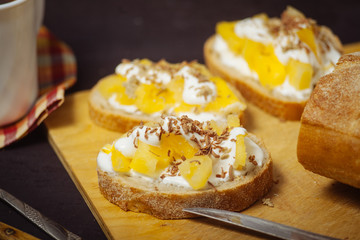 Pineapple sandwiches, on a black, textured table. Breakfast.
