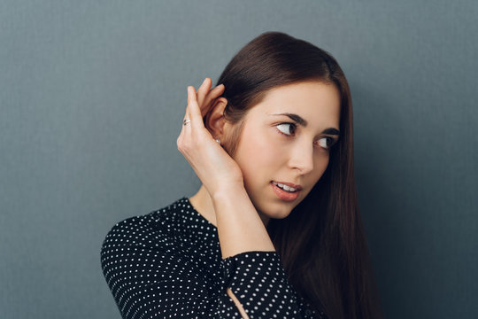 Young woman making a hearing gesture