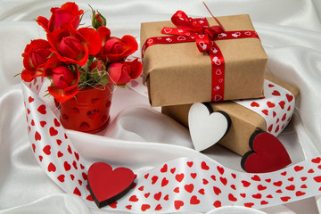 red and white otkrtyka with hearts, a bucket of roses, a gift and ribbons for Valentine's Day