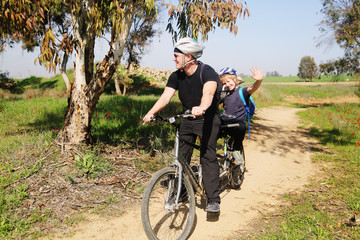 father with autistic 10 years old son ride a tandem bike