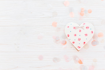 pink cookie heart on white rustic wooden background with confetti flat lay in soft light. happy valentine's day. happy mother's women's day greeting card. space for text