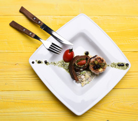 Baked pork steak in circle on salad near tomato