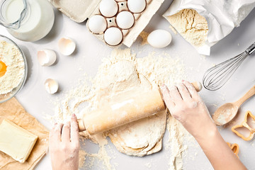 Baking preparation. Raw dough and cutters for the holiday cookies on a white table. Top view.