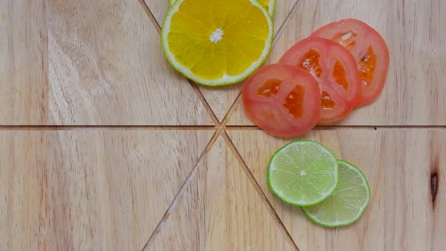 Timelapse stop motion, fruit and vegetables, being organized on top of a wooden board, divided and cut, including oranges, eggplant, tomato, onions, lemons and radish