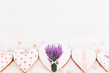 cookie hearts with lavender flowers on white rustic wooden background with confetti flat lay. space for text. happy mother's day greeting card.  happy valentine's day or women's