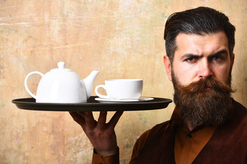 Barman with serious face serves tea or coffee