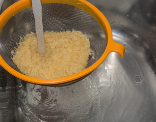 Reis waschen im sieb mit wasser