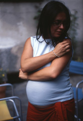 portrait of pregnant woman on a summer day in the garden of her house