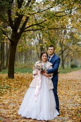 Bride and groom in a park kissing.couple newlyweds bride and groom at a wedding in nature green forest photo portrait.Wedding Couple