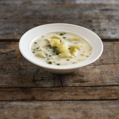 Cheese creamy soup with green peas and vegetables