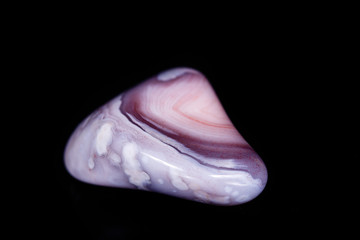 Macro mineral stone Agate pink Persian on a black background