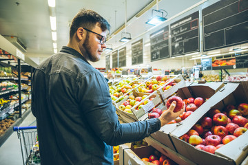 man chose apples in the store