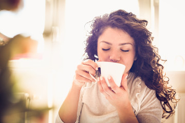 Enjoy in morning coffee. Young woman.