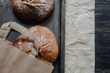 Freshly baked bread lying on a baking tray with flour, flat lay
