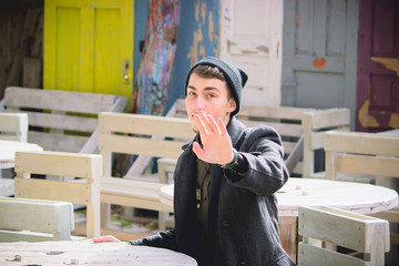 the boy in the street gently waving his hand and smile