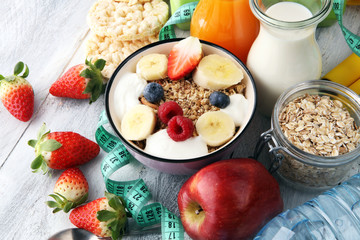 muesli with dairy and fruit, healthy lifestyle. bowl of cereal, fruit and dumbbell