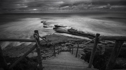 Beautiful rocky beach in the Portuguese coastline in a stormy day. Seascape. Long exposure