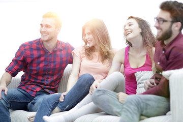 group of cheerful friends sitting on the couch