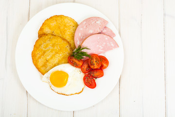 Potato pancakes, fried egg, sausage for breakfast