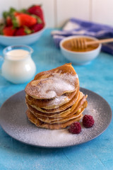 Fluffy and delicate pancakes with honey, milk and berries.