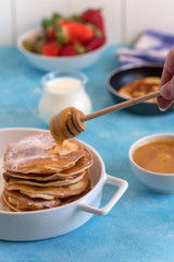 Fluffy and delicate pancakes with honey, milk and berries.