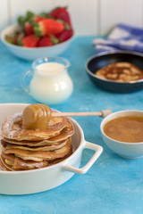 Fluffy and delicate pancakes with honey, milk and berries.