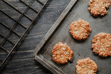 Glutenfree homemade oatmeal cookies on a rustic tray on dark wooden table
