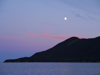 Colorful Landscape in Alaska USA - black mountain and pink sky contrast with a small moon in the sky