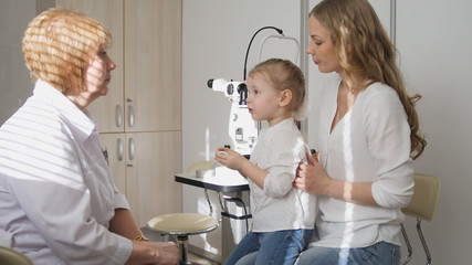 Ophthalmologist in clinic explains diagnosis girl's eyesight