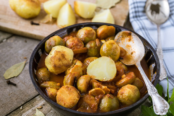 Roasted brussels sprouts with potatoes in homemade ceramic bowl.