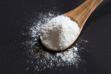 Baking soda (sodium bicarbonate) on a wooden spoon